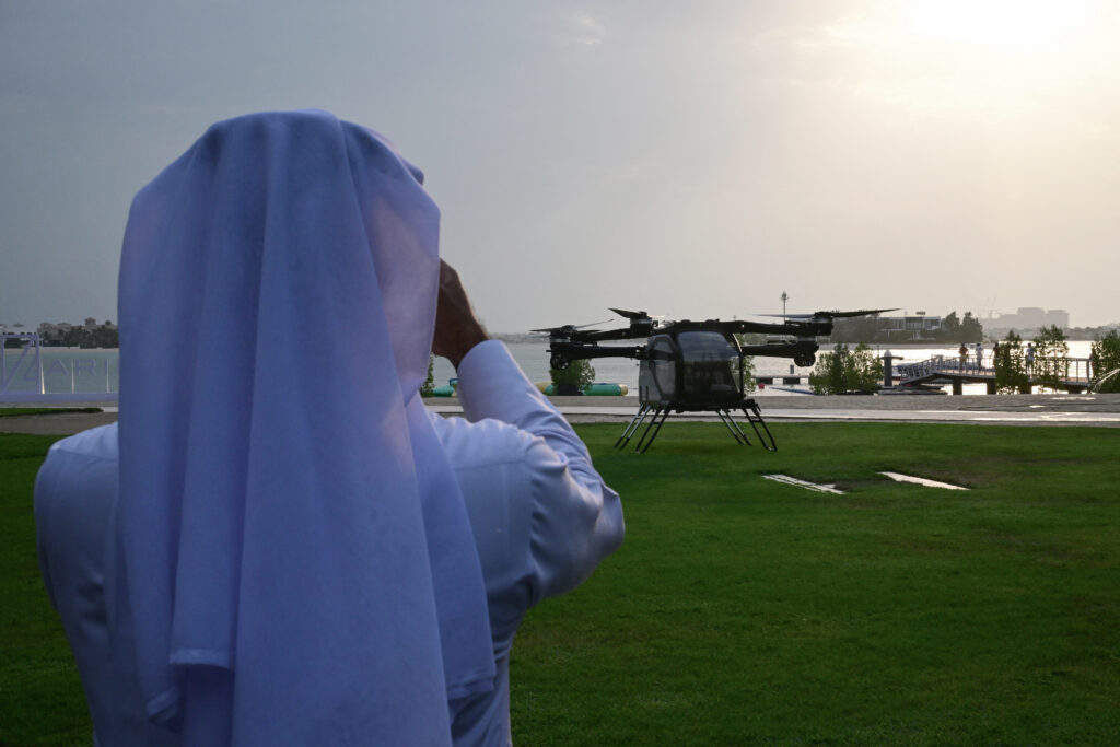 A man captures images of the modular Aridge X3-F (Air Module of the Land Aircraft Carrier) by China's flying car maker Aridge, Asia’s largest, during its presentation and flight demonstration in Dubai on October 12, 2025. (Photo by Giuseppe CACACE / AFP)